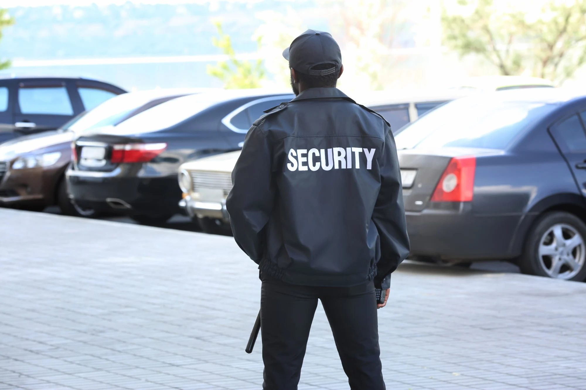 Security officer patrolling commercial vehicle parking lot enforcing facility physical security and safety regulations