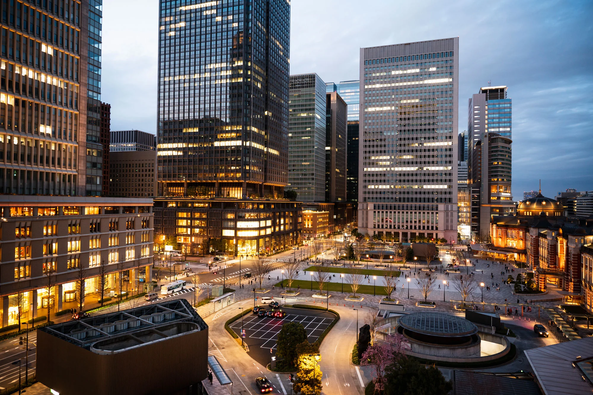 Illuminated modern smart city plaza and pedestrian center surrounded by corporate towers managed by Disrupt-X HSEQ