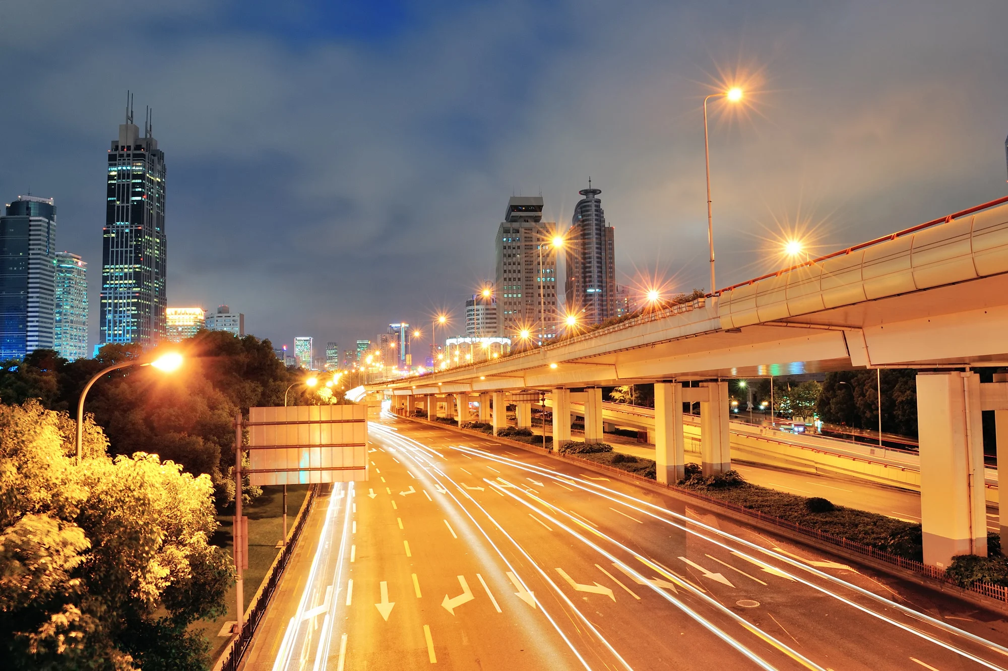 Illuminated multi-tier highway overpass and city towers representing urban transportation safety in Disrupt-X HSEQ
